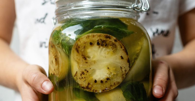 Marinades - Crop unrecognizable person with jar of pickled zucchini